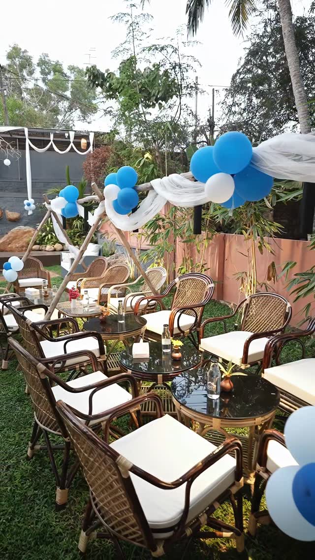 Birthday setup with balloon arch, teepee frame and cane seating