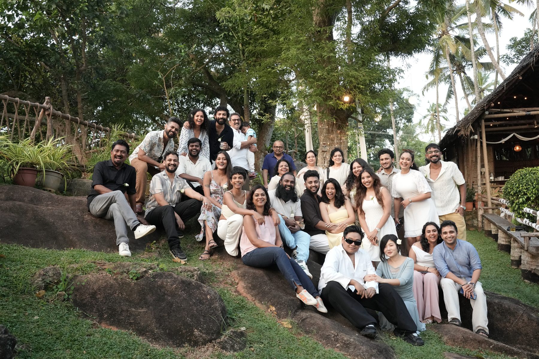 A large group of guests gathered on the rocks and lawn at Cosy Concepts